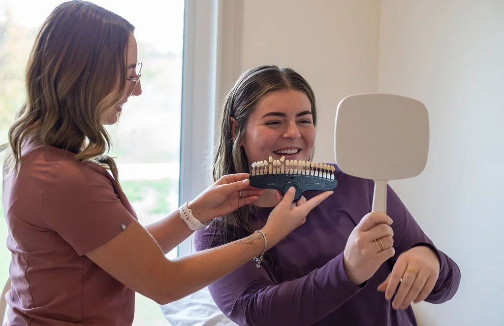 Client reviewing her shade in a mirror during a consult