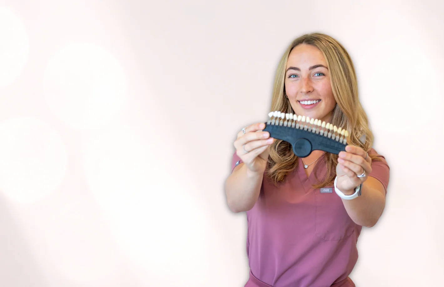 Smiles By Fayth technician holding a tooth shade guide