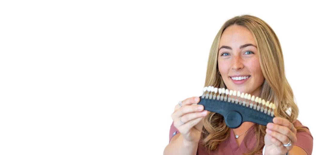 Smiles By Fayth technician holding a tooth shade guide